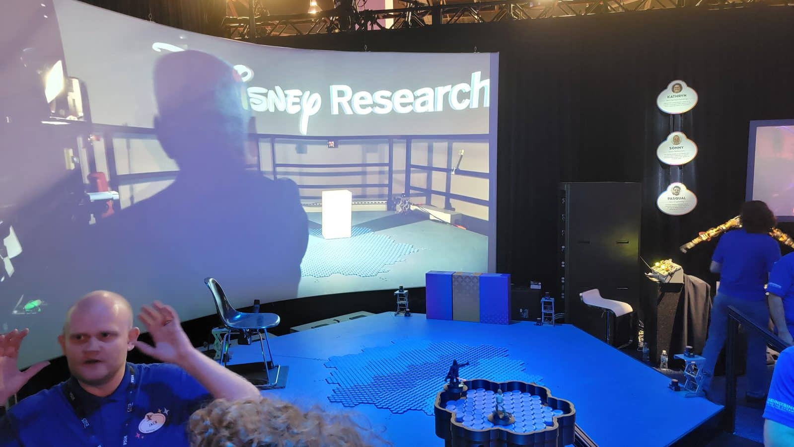 Disney Research HoloTile floor display at D23 2024 in Anaheim with a tabletop version holding Darth Vader and Luke Skywalker figures in front of the full size floor and a curved screen
