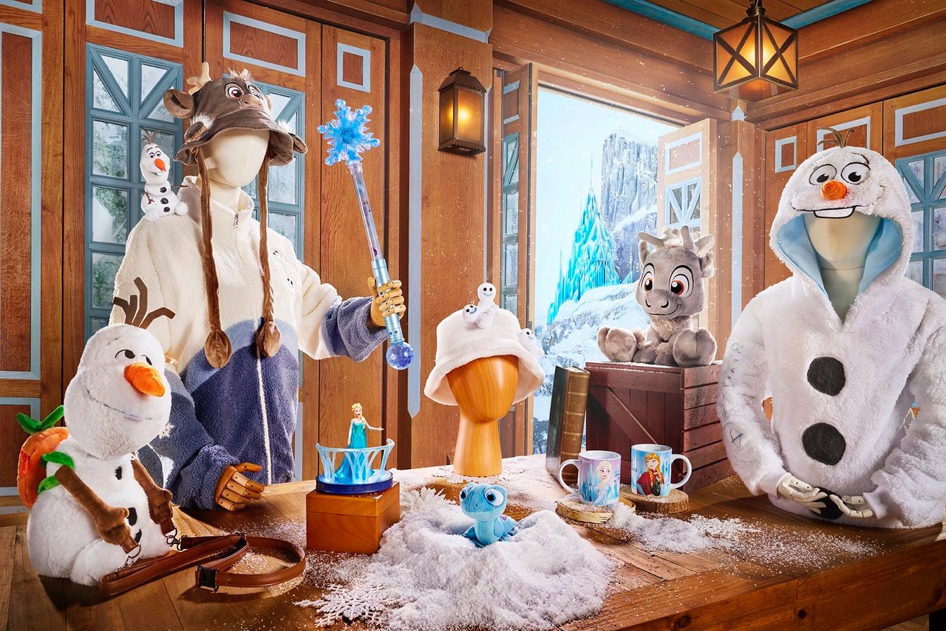 Life size Frozen characters in a wooden cabin Olaf a reindeer figure and a large snowman snow on the floor and icy backdrop