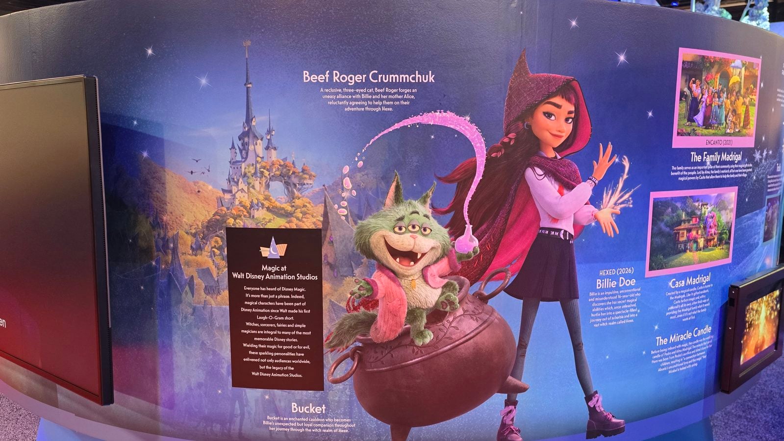 Colorful Encanto character display on a blue wall featuring Mirabel and a green creature with castle artwork in the background and character profiles text panels