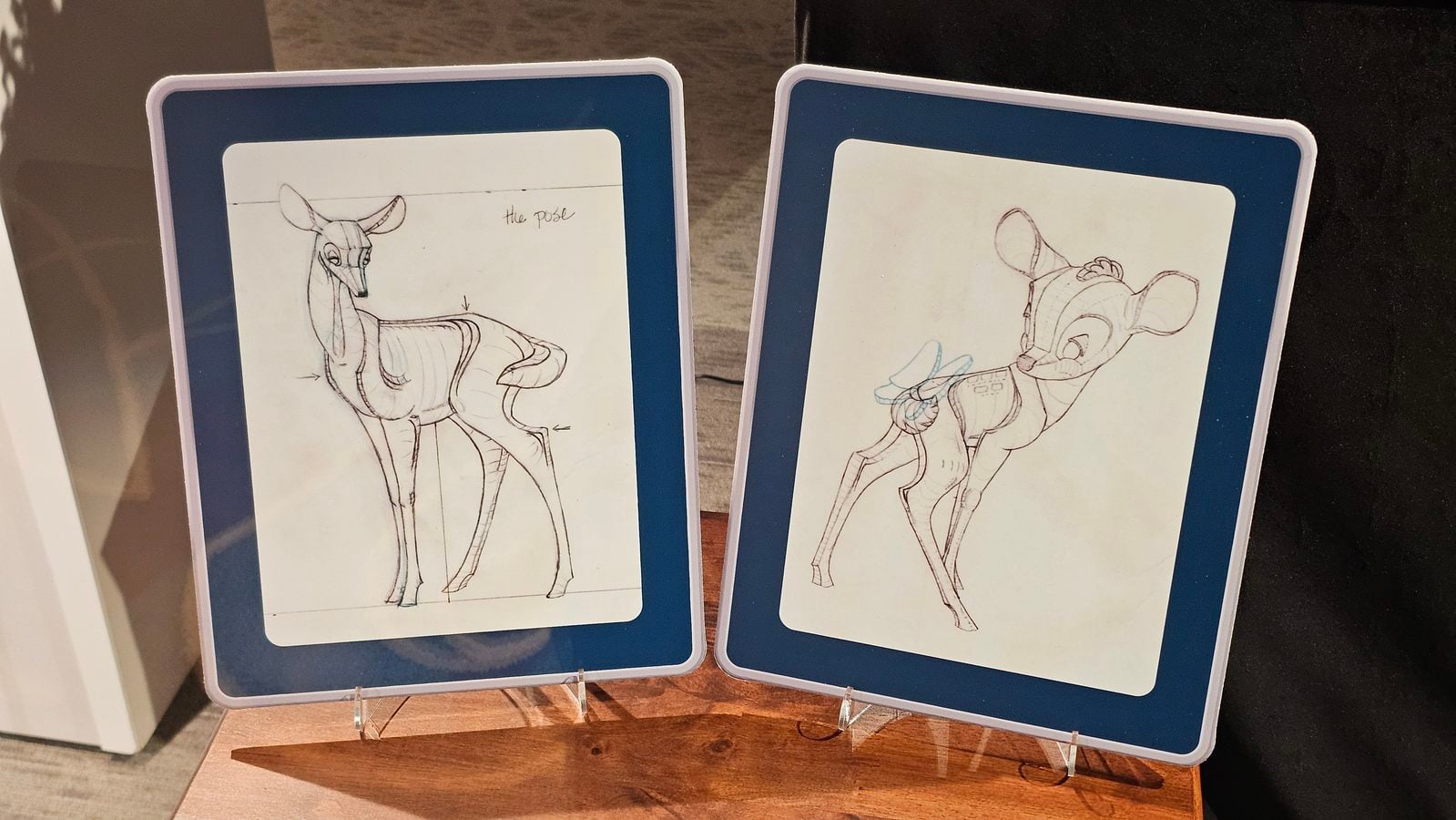 Two pencil sketches of stylized deer characters displayed on blue framed cards side by side posed as character concept art