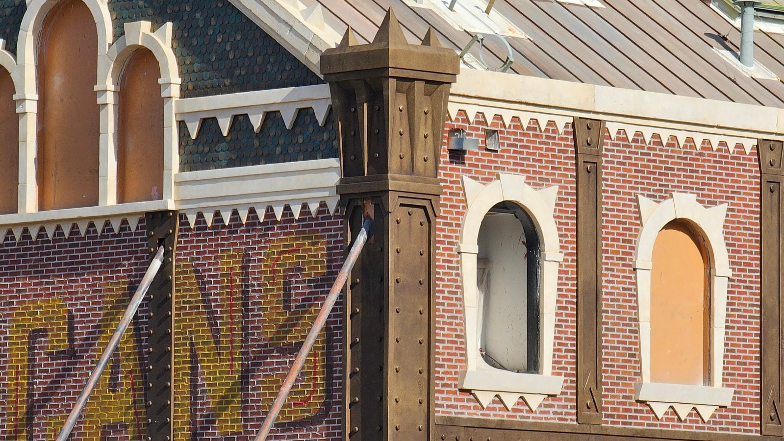 Decorative brick building facade with arched openings and dark riveted steel columns