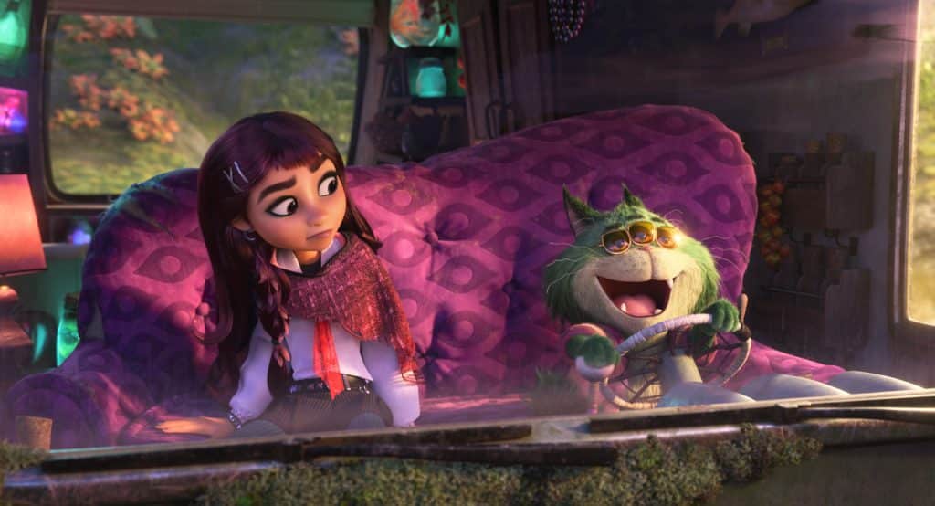 Girl with braided hair sits on a purple patterned bus seat sharing a ride with a green furry creature at the wheel both inside a colorful vehicle