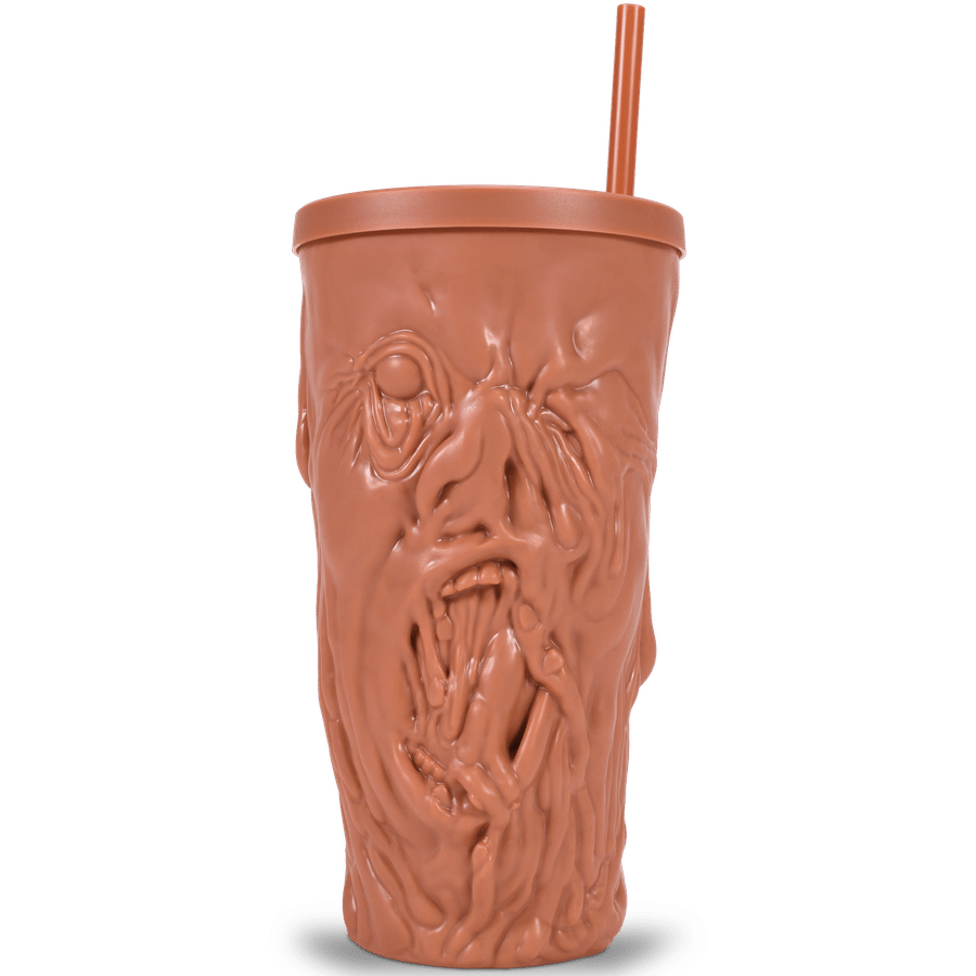 Orange brown tiki mug with a carved face and a tall straw protruding from the top