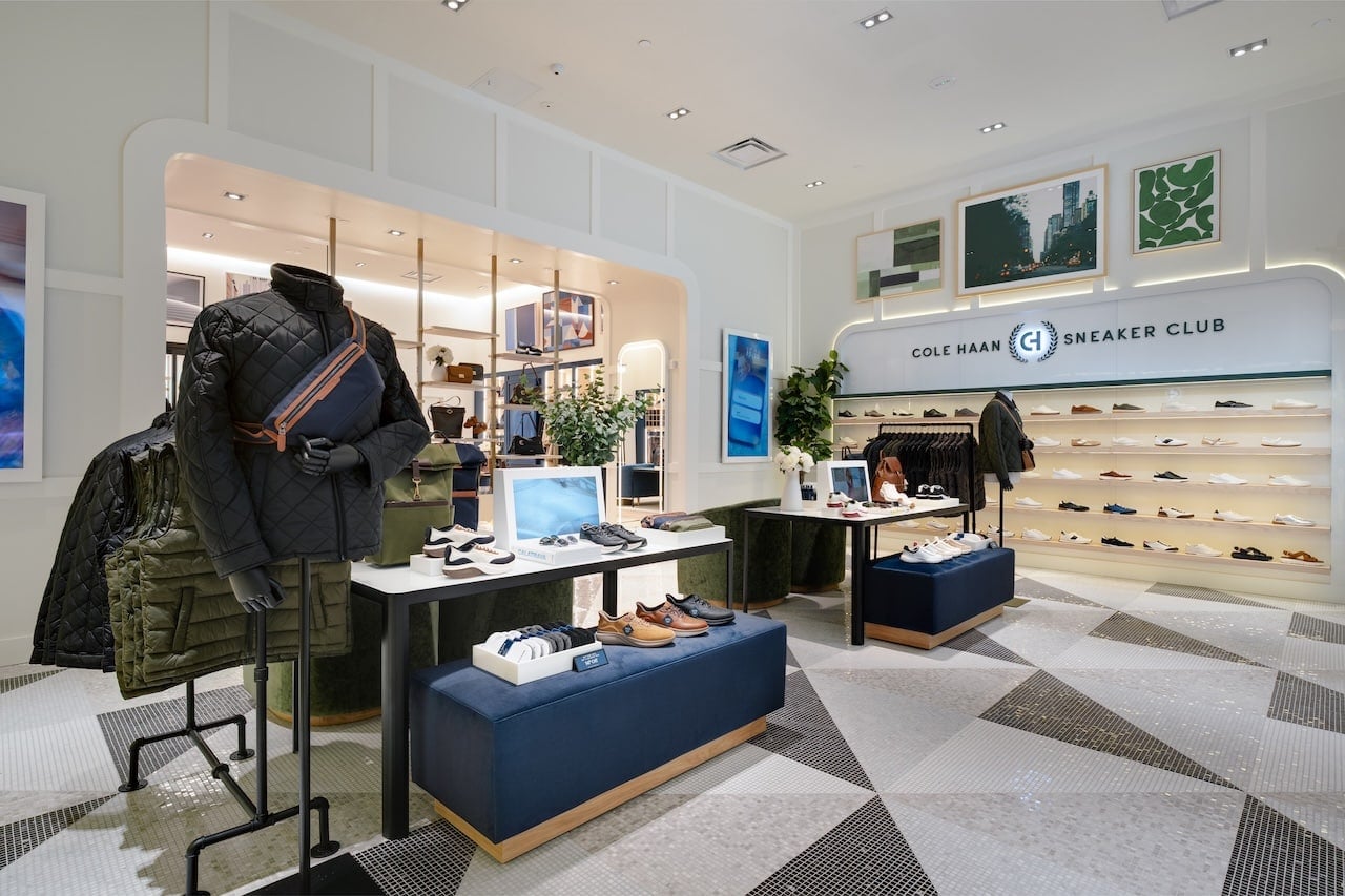Interior of Cole Haan Sneaker Club store with shoe shelves displays and seating areas