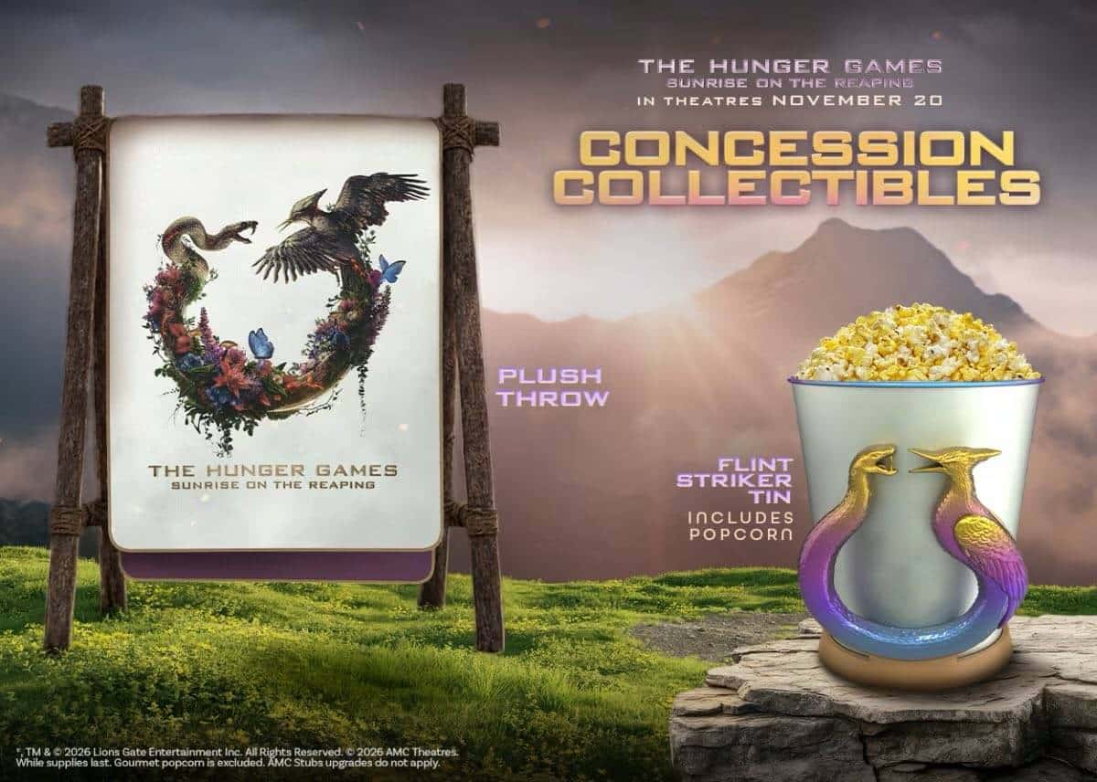 Promotional Hunger Games display with a sign featuring a wreath logo and a popcorn tin with two colorful birds on a rocky pedestal
