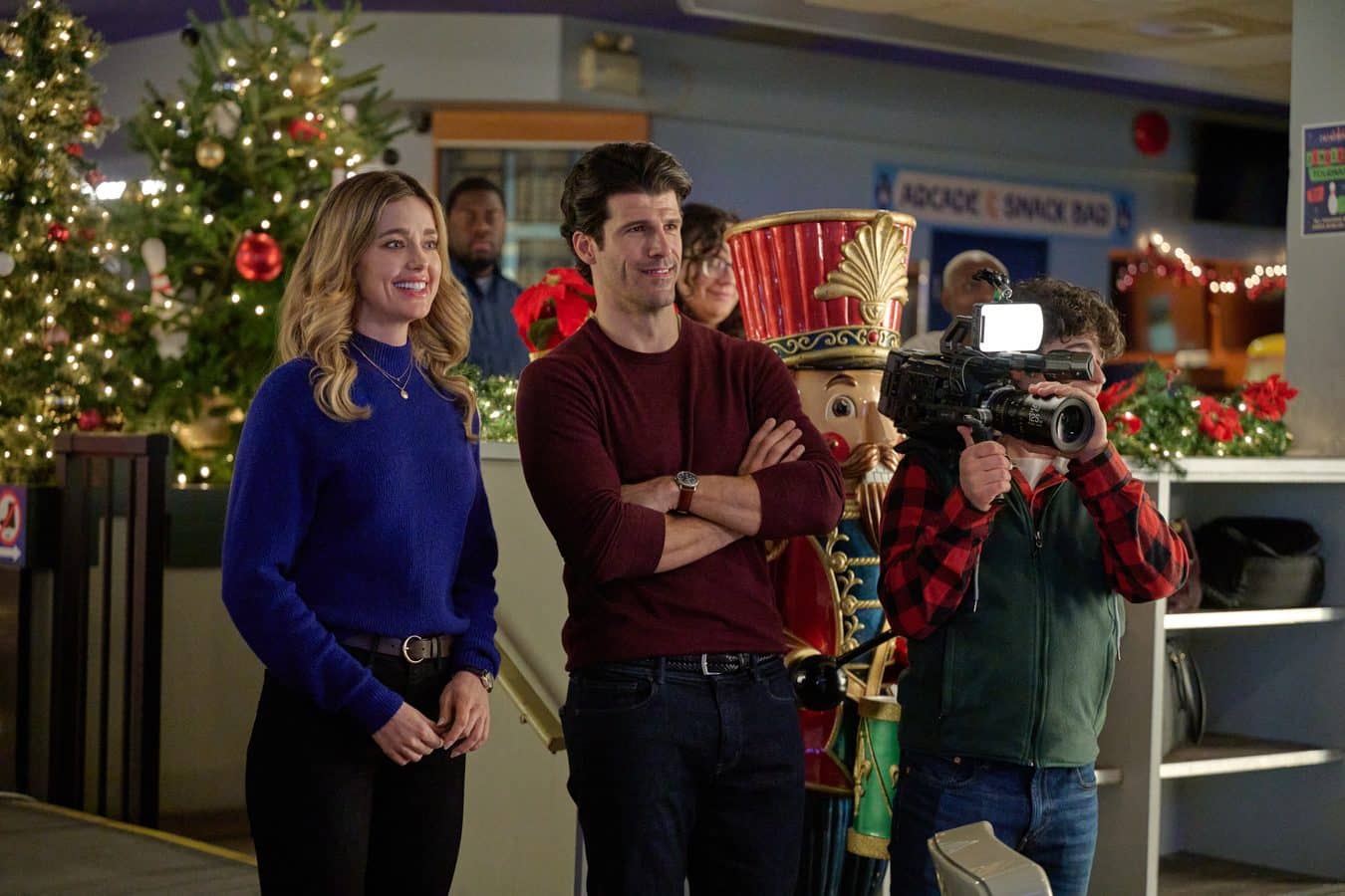 Ashley Newbrough and Franco Lo Presti watch as a camera operator films inside the Wonderlanes bowling alley in Winter Wonderlanes